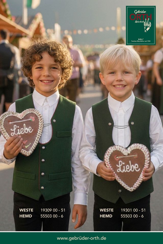 Zwei Jungen in Trachten mit Herz-Lebkuchen, lächelnd auf Volksfest.
