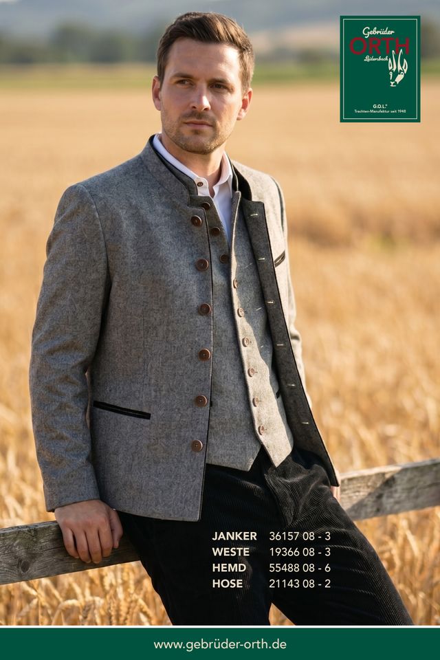 Herbstlicher Herr in Wolljacke mit Weste und Hose, sitzend auf Feldmauer, traditionelle Kleidung.