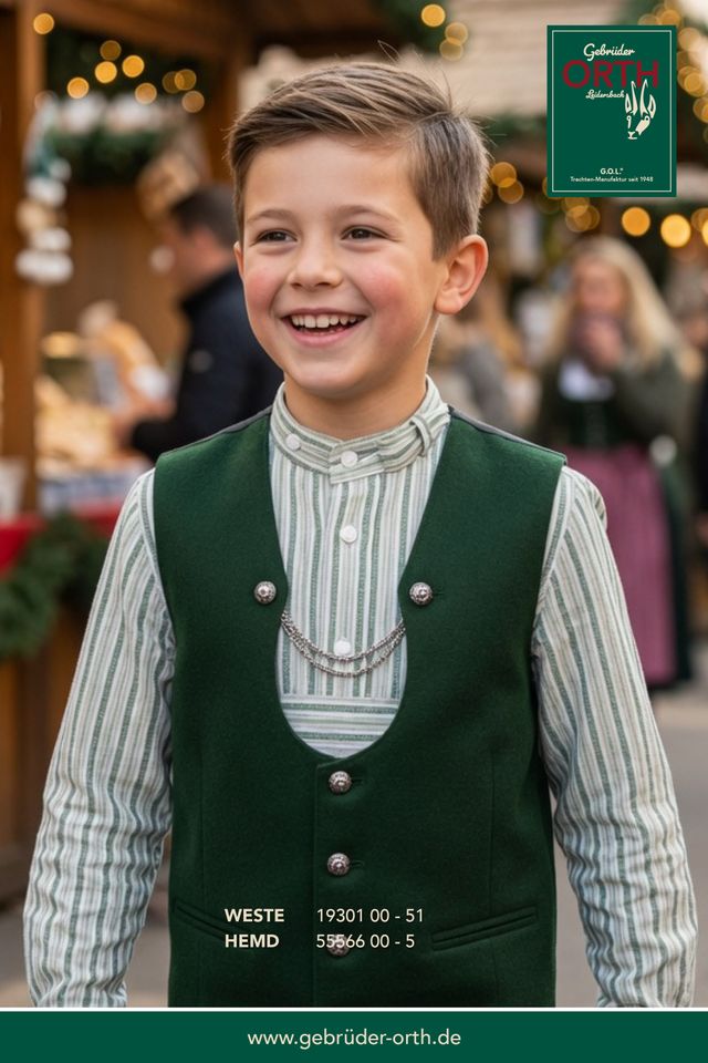 Junge in grünem Weste und gestreiftem Hemd lachend auf Weihnachtsmarkt.